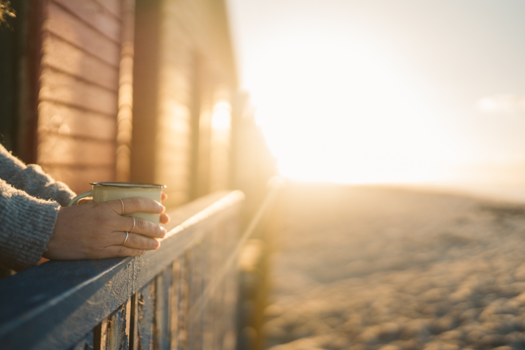 Image of person with coffee cup at sunrise